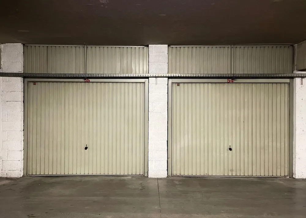 Concrete garage floor in front of two closed overhead doors