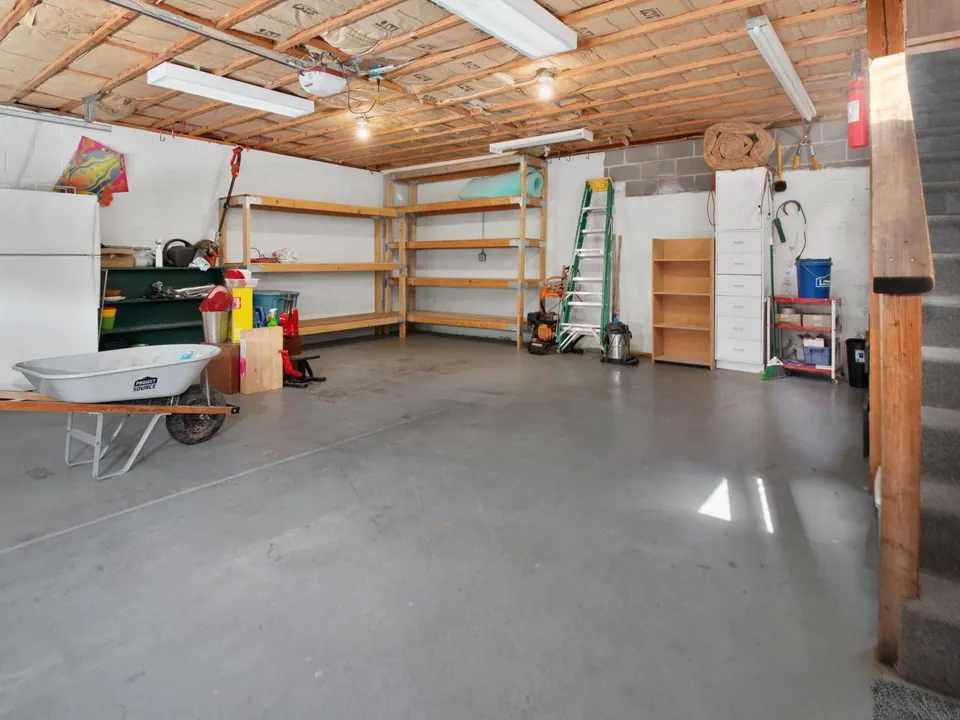 Residential garage with a smooth gray concrete floor and storage shelving
